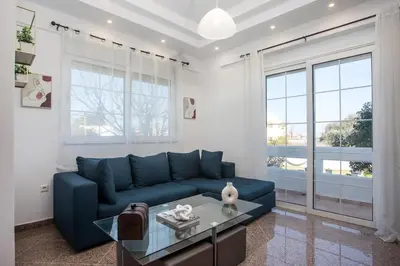 a living room with a blue couch and a table at Malibu Villa in Kremasti