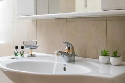 a white sink with water coming out of it at Malibu Villa in Kremasti