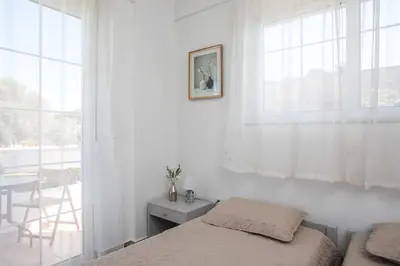 a bedroom with a bed and a window and a table at Malibu Villa in Kremasti