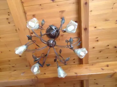 a metal chandelier hanging on a wooden wall at Villa Efraim Amalia in Halki