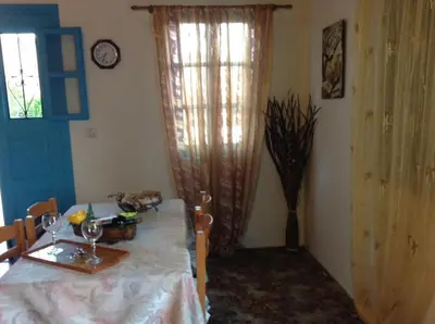 a dining room with a table and a window at Villa Efraim Amalia in Halki