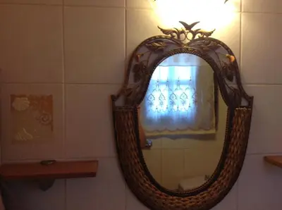 a mirror in a bathroom with a window at Villa Efraim Amalia in Halki