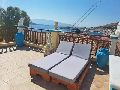 a bed on a balcony with a view of the water at Villa Efraim Amalia in Halki