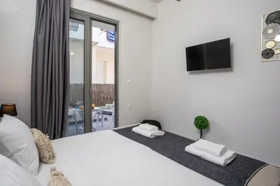 a bedroom with a white bed with a tv on the wall at Ixia del Mar Apartment in Ixia