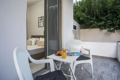 a white table and chairs on a balcony with a bed at Ixia del Mar Apartment in Ixia