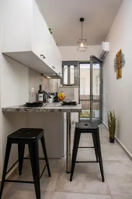 a kitchen with two stools and a counter in a room at Ixia del Mar Apartment in Ixia