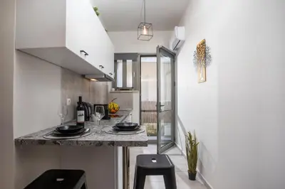 a kitchen with a counter and stools in a room at Ixia del Mar Apartment in Ixia