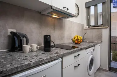 a kitchen with a sink and a fruit bowl on a counter at Ixia del Mar Apartment in Ixia