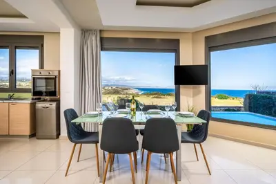 a kitchen and dining room with a table and chairs at Aqua Natura Villas in Lachania