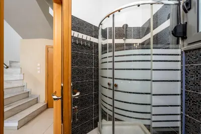 a bathroom with a glass shower and stairs at Aqua Natura Villas in Lachania