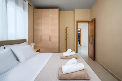 a bedroom with a large white bed with towels on it at Aqua Natura Villas in Lachania