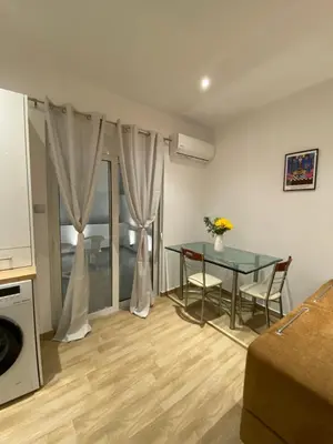 a living room with a glass table and a kitchen at Melograno di Rodi 8 in Rhodes Town