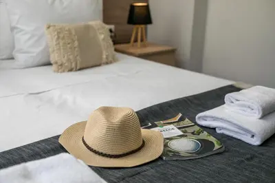 a straw hat sitting on a bed with towels at Ixia del sol Apartment in Ixia