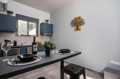 a kitchen with a table with plates and wine glasses at Ixia del sol Apartment in Ixia