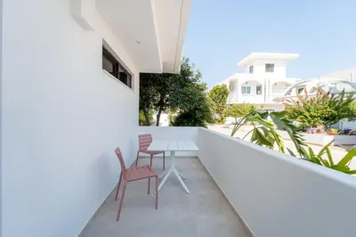 a balcony with two chairs and a table at Paloma Seaesta Cabanas in Rhodes Town