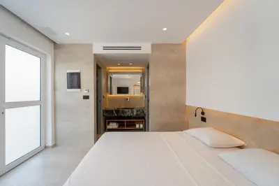 a bedroom with a large white bed and a window at Paloma Seaesta Cabanas in Rhodes Town