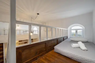 a white room with a bed and a balcony at Lemonitissa Villa in Symi