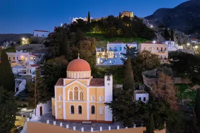 a church on a hill with a town at night at Lemonitissa Villa in Symi
