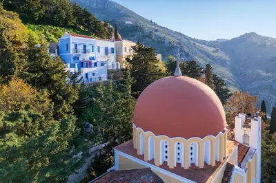 a building with a dome on top of a mountain at Lemonitissa Villa in Symi