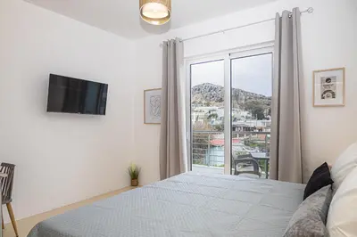 a bedroom with a bed and a large window at Gaia Rooms in Vrachonisída touArchangélou