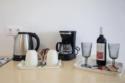 a counter with a coffee maker and a bottle of wine at Gaia Rooms in Vrachonisída touArchangélou