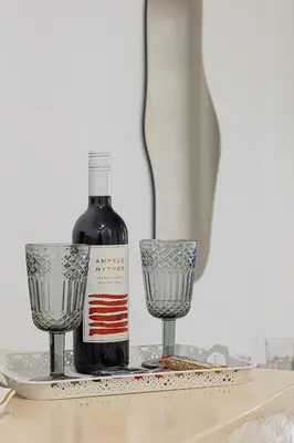 a bottle of wine and two glasses on a table at Gaia Rooms in Vrachonisída touArchangélou
