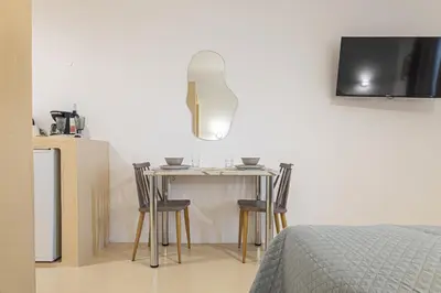 a bedroom with a table with chairs and a tv at Gaia Rooms in Vrachonisída touArchangélou