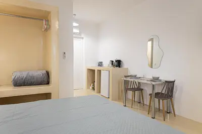 a bedroom with a bed and a table with chairs at Gaia Rooms in Vrachonisída touArchangélou