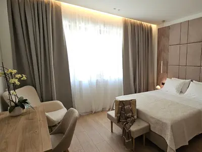 a bedroom with a bed and a table and a window at S & E luxury city residences in Rhodes Town