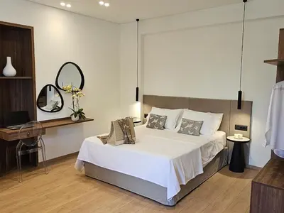 a bedroom with a large white bed and a mirror at S & E luxury city residences in Rhodes Town