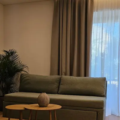 a living room with a green couch and a table at S & E luxury city residences in Rhodes Town