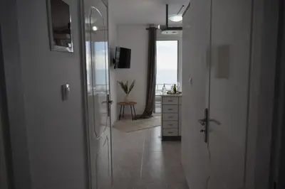 a hallway with a door leading to a room with the ocean at Eraya Apartment in Haraki