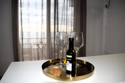 a bottle of wine and two wine glasses on a table at Eraya Apartment in Haraki