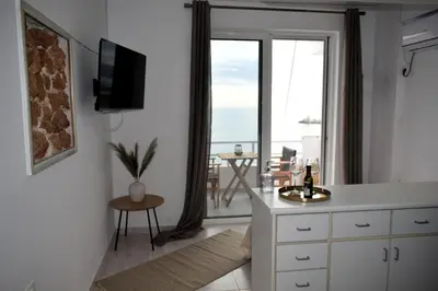 a white kitchen with a view of the ocean at Eraya Apartment in Haraki