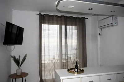 a living room with a window with a curtain at Eraya Apartment in Haraki