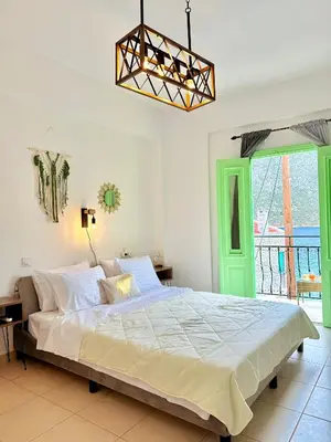 a bedroom with a large bed with a green door at Marine's apartments in Symi
