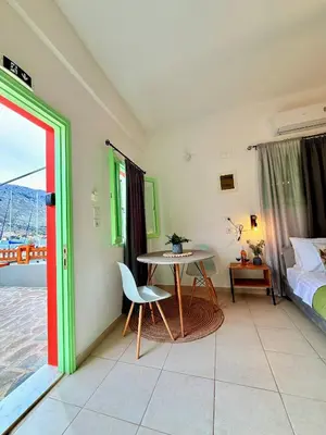 a room with a table and a bed and a bedroom at Marine's apartments in Symi