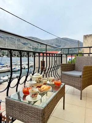 a tray of food on a glass table on a balcony at Marine's apartments in Symi