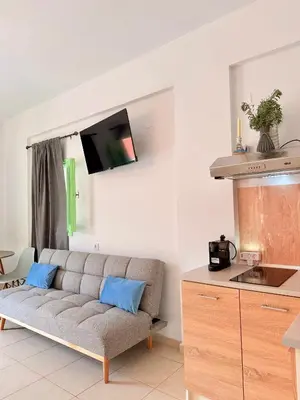a living room with a couch and a kitchen at Marine's apartments in Symi
