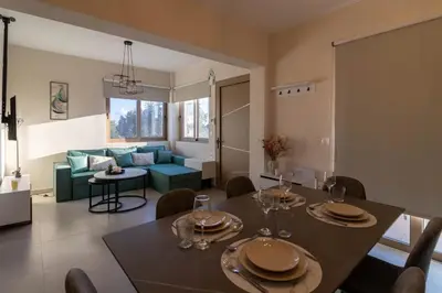 a dining room and living room with a table and chairs at Kolymbia Bella View House in Kolimbia