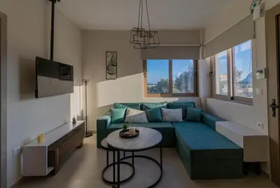 a living room with a blue couch and a table at Kolymbia Bella View House in Kolimbia