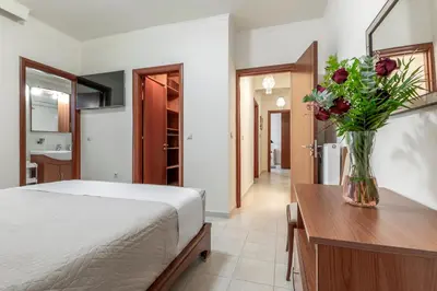 a bedroom with a bed and a vase of flowers at Sunny Palm Villa in Ialyssos