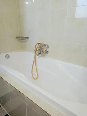 a bath tub with a faucet in a bathroom at Sunny Palm Villa in Ialyssos