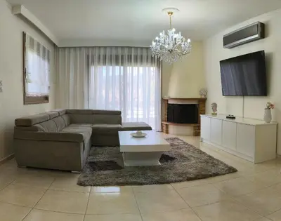 a living room with a couch and a table at Sunny Palm Villa in Ialyssos