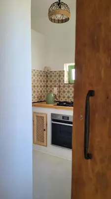 a kitchen with a stove and a door in it at Makariospiti - Villa Vera in Malona Village