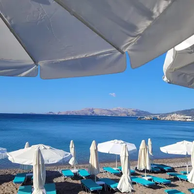 a group of umbrellas and chairs on a beach at Makariospiti - Villa Vera in Malona Village