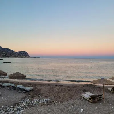 a beach with umbrellas and chairs and the ocean at Makariospiti - Villa Vera in Malona Village