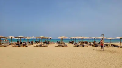 a beach with lounge chairs and umbrellas and the ocean at Makariospiti - Villa Vera in Malona Village