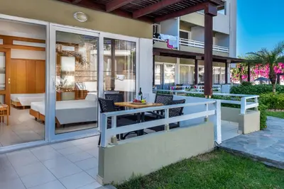 a home with a patio with a table and chairs at Sirene Beach Hotel in Ixia