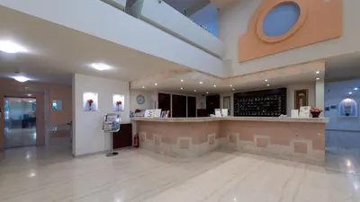 a large lobby with a bar in a building at Sirene Beach Hotel in Ixia
